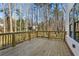 Wooden back deck overlooking a wooded yard with railing along the perimeter, a perfect spot for entertaining at 1977 Westwood Se Cir, Smyrna, GA 30080