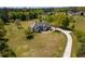 Aerial view of a beautiful home with a long driveway, surrounded by lush green landscaping and mature trees at 815 Spring View Ct, Covington, GA 30014