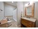 Stylish bathroom features a wood vanity, granite countertop, and a bathtub with shower at 815 Spring View Ct, Covington, GA 30014