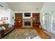 Bright living room featuring stone fireplace, built-in shelves, and French doors at 815 Spring View Ct, Covington, GA 30014