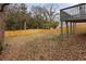 View of fenced backyard from under the deck with grassy lawn area and trees at 1104 Oak Knoll Se Ter, Atlanta, GA 30315