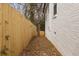 Narrow side yard shows new fencing and a white brick wall along the side of the house at 1104 Oak Knoll Se Ter, Atlanta, GA 30315