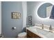 Elegant powder room with a marble countertop, modern sink, updated faucet, and a decorative round LED mirror at 1030 Whistling Swan Pl, Marietta, GA 30066