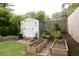 Backyard featuring a storage shed, raised garden beds, and well-maintained landscaping at 545 Woodale Se Dr, Smyrna, GA 30080