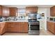 Functional kitchen with stainless steel appliances, wood cabinets, and adjacent laundry room at 209 Sweetwater Trl, Villa Rica, GA 30180