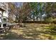 Backyard showcasing a large, well-maintained lawn with mature landscaping and a stone retaining wall at 4095 Oberon Se Ct, Smyrna, GA 30080