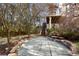 Backyard featuring a stone pathway, stone retaining wall, and lush landscaping with trees and shrubs at 4095 Oberon Se Ct, Smyrna, GA 30080