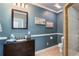 Cozy bathroom featuring a vanity with granite countertop, framed mirror, and decorative beach themed art at 4095 Oberon Se Ct, Smyrna, GA 30080