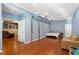 Spacious bedroom featuring hardwood floors, blue walls, and an open doorway to a seating area at 4095 Oberon Se Ct, Smyrna, GA 30080