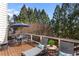Wooden deck with an outdoor dining area, lounge chairs, and views of mature trees at 4095 Oberon Se Ct, Smyrna, GA 30080