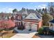Beautiful two-story brick home with a two-car garage, well-manicured lawn, and mature trees, all under a blue sky at 4095 Oberon Se Ct, Smyrna, GA 30080