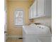 Bright laundry room features a washer, dryer, window, and built-in shelving at 4095 Oberon Se Ct, Smyrna, GA 30080