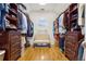 Spacious walk-in closet with custom shelving, hardwood floors and a center bench at 4095 Oberon Se Ct, Smyrna, GA 30080