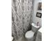 Neutral-toned bathroom with decorative patterned shower curtain and framed art at 6756 Brookwood Cir, Jonesboro, GA 30043