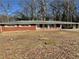 Single story brick home with small porch and carport surrounded by trees at 6756 Brookwood Cir, Jonesboro, GA 30043