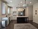 Spacious kitchen with stainless steel appliances, white cabinetry, a dark center island, and modern pendant lighting at 1200 Bar Harbor Pl, Lawrenceville, GA 30044