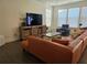 Comfortable living room with an oversized leather couch, neutral walls, and dark laminate floors at 1200 Bar Harbor Pl, Lawrenceville, GA 30044