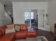 Cozy living room with a comfortable orange sectional sofa, neutral tones, and a glass door leading to another room at 1200 Bar Harbor Pl, Lawrenceville, GA 30044