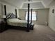 Spacious main bedroom featuring a four-poster bed, tray ceiling, and plush carpeting at 1200 Bar Harbor Pl, Lawrenceville, GA 30044