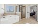 Bathroom featuring a soaking tub and walk-in shower with glass enclosure at 1263 Polk Xing, Mcdonough, GA 30252
