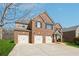 Traditional brick home showcasing a three-car garage and well-maintained lawn at 1263 Polk Xing, Mcdonough, GA 30252