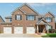 Charming brick-front home featuring a three-car garage, black shutters and trim, and a welcoming entrance at 1263 Polk Xing, Mcdonough, GA 30252