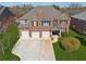 Beautiful brick home featuring a three-car garage and well-manicured lawn at 1263 Polk Xing, Mcdonough, GA 30252