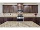Kitchen with stainless steel oven, granite countertops, and dark wood cabinets at 1263 Polk Xing, Mcdonough, GA 30252
