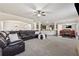 Spacious living room with a large leather sectional, open floorplan, and modern ceiling fan at 1263 Polk Xing, Mcdonough, GA 30252