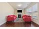Comfortable living room with fireplace, TV, hardwood floors, and two red sofas at 1263 Polk Xing, Mcdonough, GA 30252