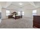 Expansive primary bedroom has a tray ceiling, a large bed, and lots of natural light at 1263 Polk Xing, Mcdonough, GA 30252