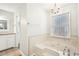 Elegant bathroom with a jacuzzi tub, chandelier, and tile accents at 105 Spring Forest Way, Sharpsburg, GA 30277