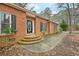 Close up view of a brick home with a curved brick staircase leading to the front door and surrounding landscaping at 105 Spring Forest Way, Sharpsburg, GA 30277