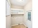 Functional laundry room with built-in shelving and access to garage, simplifying household chores at 105 Spring Forest Way, Sharpsburg, GA 30277