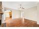 An empty living room with hardwood flooring, a stone fireplace, and an open doorway to the kitchen at 105 Spring Forest Way, Sharpsburg, GA 30277