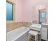 Cozy bathroom with pink walls, a built-in tub, and a stylish vanity with stool at 4000 Wieuca Ne Rd, Atlanta, GA 30342