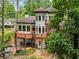 Rear exterior view showcasing the deck and patio, with an attractive pond on the grounds at 4000 Wieuca Ne Rd, Atlanta, GA 30342