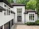 A modern home's front entrance featuring a striking white facade, large windows, and a well-manicured landscape at 4000 Wieuca Ne Rd, Atlanta, GA 30342