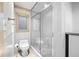 Bright bathroom with a glass-enclosed shower, toilet, window and tile floors at 4000 Wieuca Rd Ne, Atlanta, GA 30342