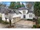 Stunning white facade with a three-car garage and a double-door entrance framed by two-story windows at 4000 Wieuca Rd Ne, Atlanta, GA 30342
