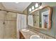 Bathroom featuring double sinks, a large mirror, and a tiled shower with a shower curtain at 7030 Cascade Palmetto Hwy, Palmetto, GA 30268