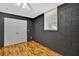 Bedroom featuring black painted brick walls, hardwood floors, and a window at 7030 Cascade Palmetto Hwy, Palmetto, GA 30268