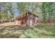Side view of the brick home showing the spacious backyard, traditional architecture, and natural setting at 7030 Cascade Palmetto Hwy, Palmetto, GA 30268