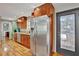 Bright kitchen showcasing stainless steel refrigerator, wooden cabinets, and access to the backyard at 7030 Cascade Palmetto Hwy, Palmetto, GA 30268