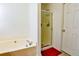 Relaxing bathroom featuring a soaking tub, glass door shower, and neutral color palette at 205 Trelawney Place, Covington, GA 30016