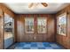 Cozy sun room featuring wood paneled walls, a ceiling fan, and views of the wooded outdoors at 28 East Boxwood Dr, Cartersville, GA 30121