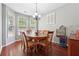 Cozy dining room with a round wooden table, six chairs, and ample natural light from bay windows at 3004 Westray Nw Ct, Marietta, GA 30064