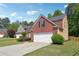 Traditional brick and siding home featuring an attached garage and manicured lawn at 3004 Westray Nw Ct, Marietta, GA 30064