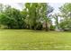 A large, grassy backyard lined with mature trees at 5678 Fern Creek Sw Dr, Lilburn, GA 30047