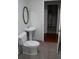 Cozy bathroom featuring a classic toilet, sink, and an oval mirror at 5678 Fern Creek Sw Dr, Lilburn, GA 30047